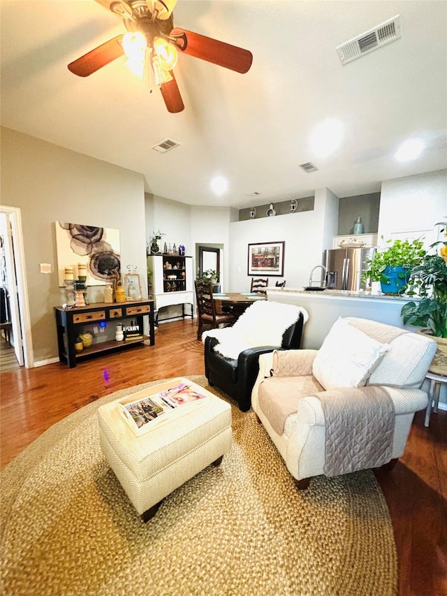 living room featuring ceiling fan and wood-type flooring