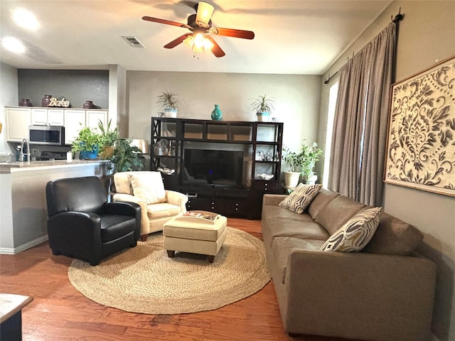 living room with ceiling fan and light hardwood / wood-style flooring