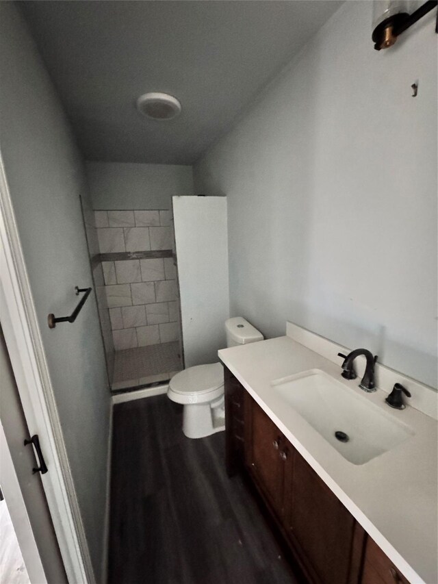 bathroom with hardwood / wood-style flooring, vanity, and toilet