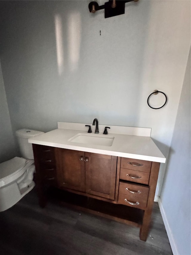 bathroom with vanity, wood-type flooring, and toilet