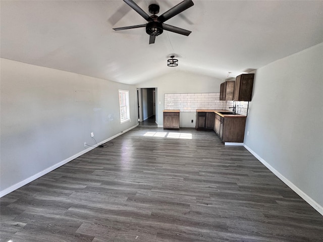 unfurnished living room with lofted ceiling, dark hardwood / wood-style floors, and ceiling fan