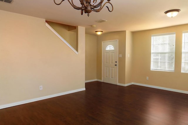 foyer entrance featuring dark hardwood / wood-style flooring and an inviting chandelier