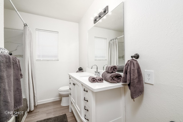 bathroom featuring walk in shower, vanity, wood-type flooring, and toilet