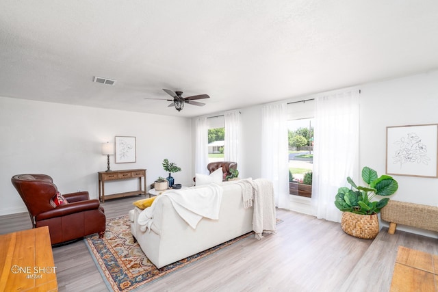 living room with ceiling fan and light hardwood / wood-style flooring