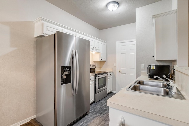 kitchen featuring sink, stainless steel appliances, dark hardwood / wood-style floors, a textured ceiling, and white cabinets