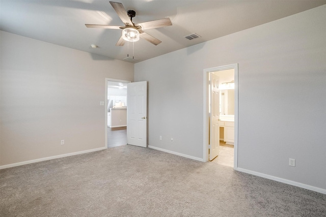 unfurnished bedroom with ceiling fan, light colored carpet, and connected bathroom