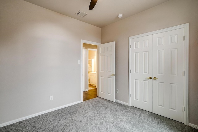 unfurnished bedroom featuring ceiling fan, a closet, and carpet