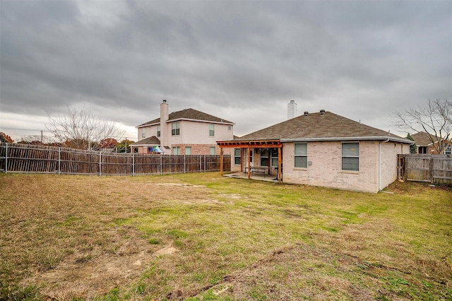 rear view of house featuring a yard and a patio area