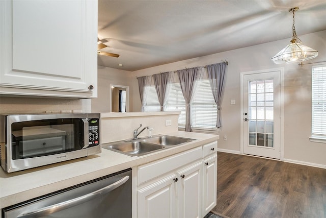 kitchen with dark wood-type flooring, sink, decorative light fixtures, white cabinetry, and stainless steel appliances