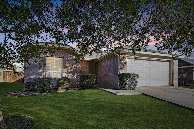 ranch-style house featuring a garage and a lawn