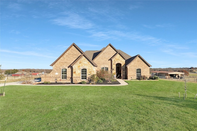 french country inspired facade with a front yard