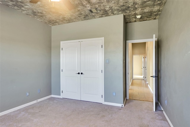 unfurnished bedroom with light carpet and a closet