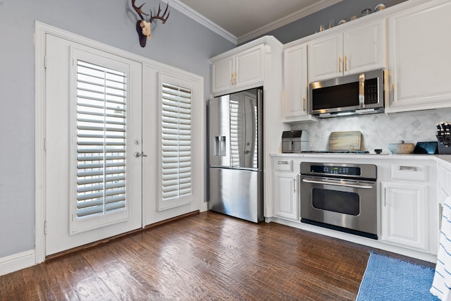 kitchen with backsplash, white cabinets, ornamental molding, plenty of natural light, and stainless steel appliances