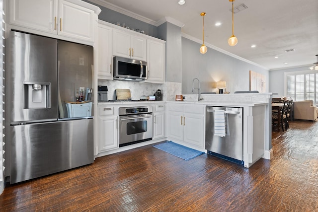 kitchen featuring kitchen peninsula, pendant lighting, stainless steel appliances, and white cabinetry