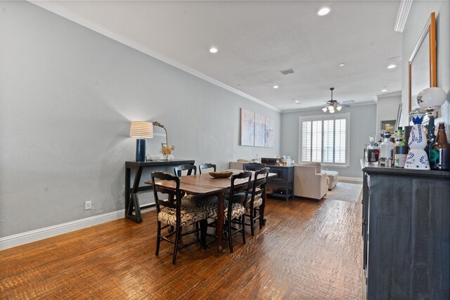 dining space with ceiling fan, dark hardwood / wood-style floors, and ornamental molding