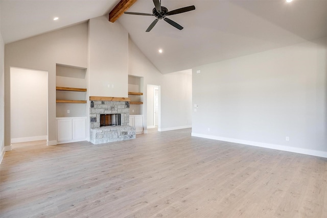 unfurnished living room featuring light hardwood / wood-style flooring, built in features, ceiling fan, and a stone fireplace