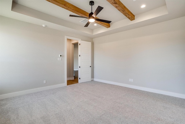 spare room featuring a raised ceiling, ceiling fan, light colored carpet, and beam ceiling