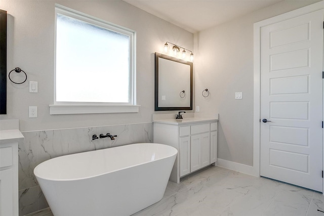 bathroom with vanity, plenty of natural light, and a bathtub