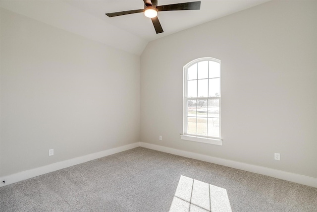 empty room featuring ceiling fan, carpet floors, and vaulted ceiling