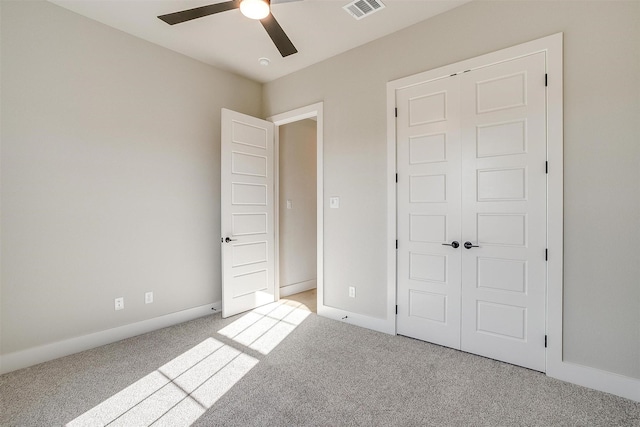 unfurnished bedroom featuring light carpet, a closet, and ceiling fan