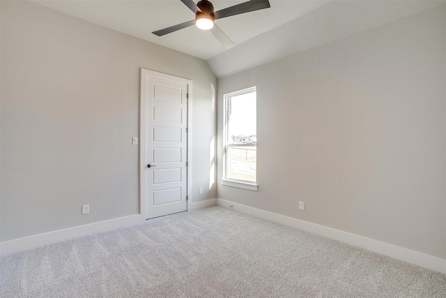 empty room with light carpet, vaulted ceiling, and ceiling fan