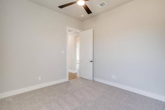 carpeted spare room with ceiling fan