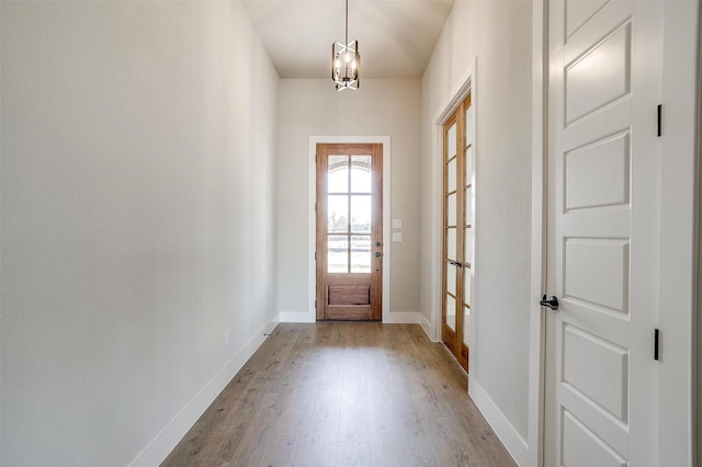 doorway with a chandelier and light hardwood / wood-style floors