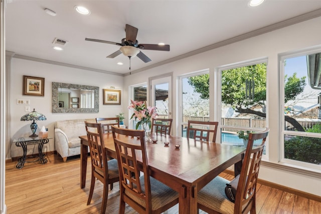 dining space featuring ceiling fan, ornamental molding, and light wood-type flooring