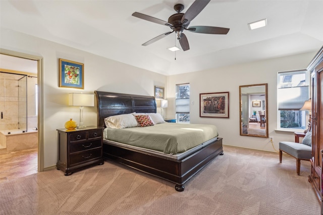 bedroom with connected bathroom, vaulted ceiling, and light colored carpet