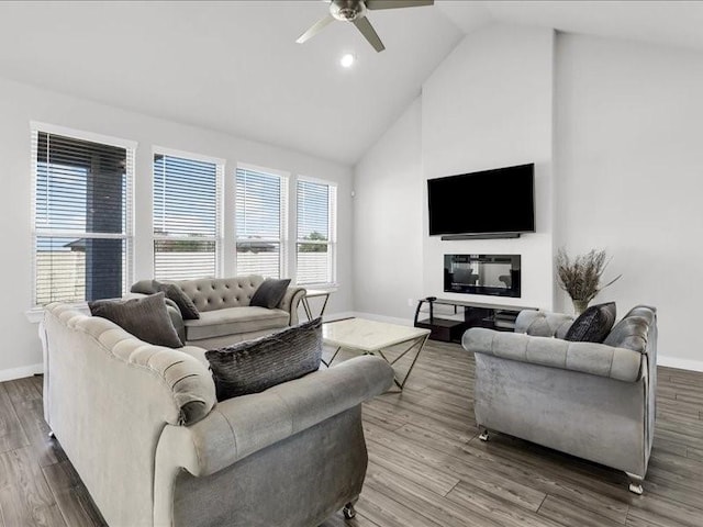 living room featuring hardwood / wood-style floors, ceiling fan, and high vaulted ceiling