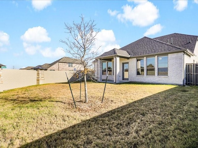 rear view of property featuring a yard