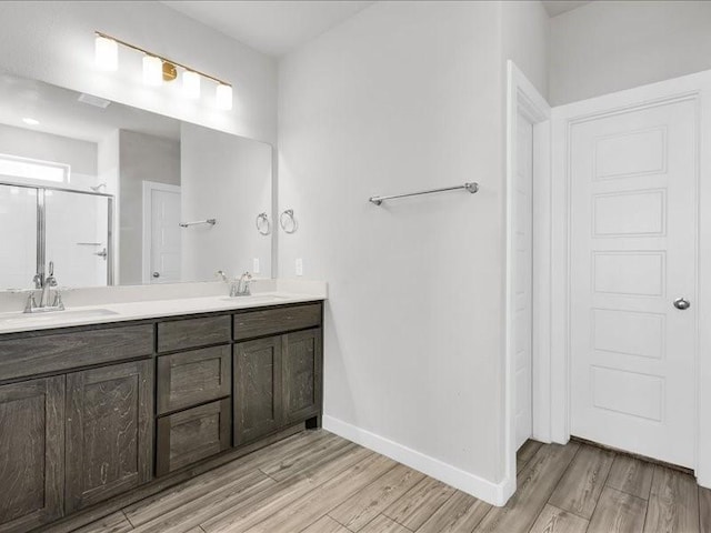 bathroom with hardwood / wood-style floors, vanity, and walk in shower