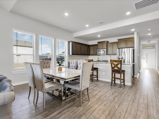 dining space with light hardwood / wood-style flooring