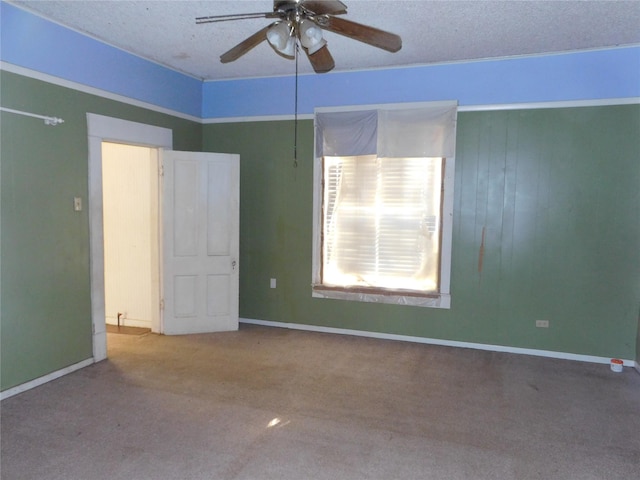 carpeted spare room featuring a textured ceiling and ceiling fan