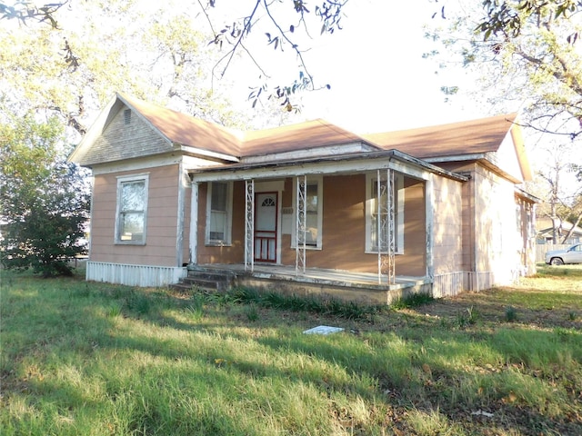 view of front of property featuring covered porch and a front yard