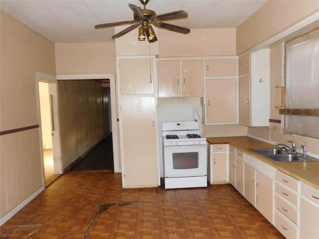 kitchen featuring ceiling fan, parquet floors, sink, and gas range gas stove