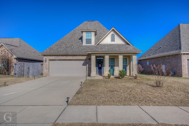 view of front of home featuring brick siding, a front lawn, roof with shingles, a garage, and driveway