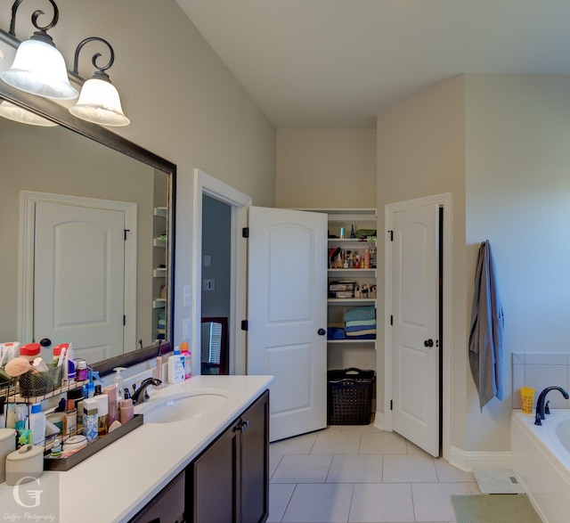 full bathroom with tile patterned floors, a closet, a garden tub, and vanity