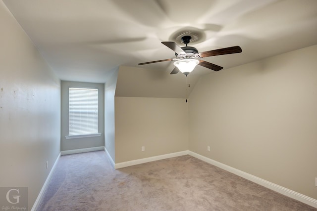 unfurnished room featuring light colored carpet, lofted ceiling, baseboards, and ceiling fan