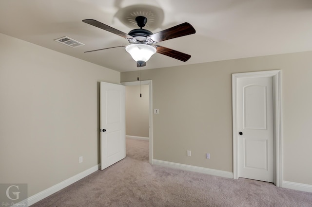 unfurnished bedroom featuring visible vents, light carpet, baseboards, and a ceiling fan