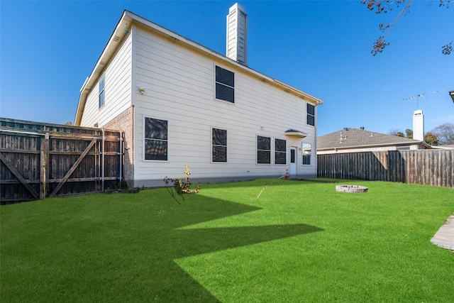 back of property featuring a yard and a fire pit