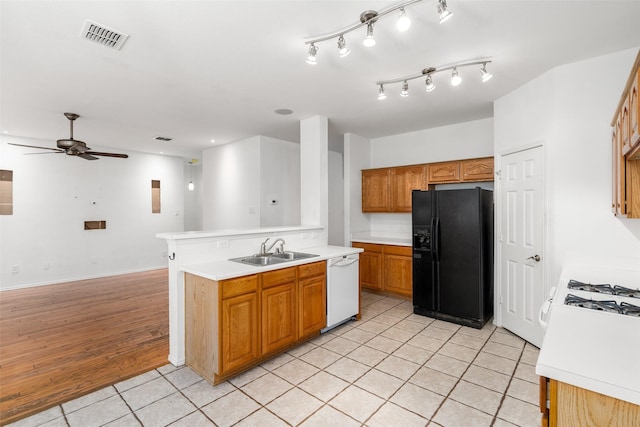 kitchen featuring black fridge with ice dispenser, white dishwasher, ceiling fan, sink, and light tile patterned flooring