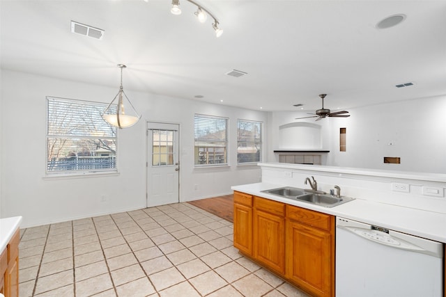 kitchen featuring white dishwasher, ceiling fan, sink, light tile patterned floors, and decorative light fixtures