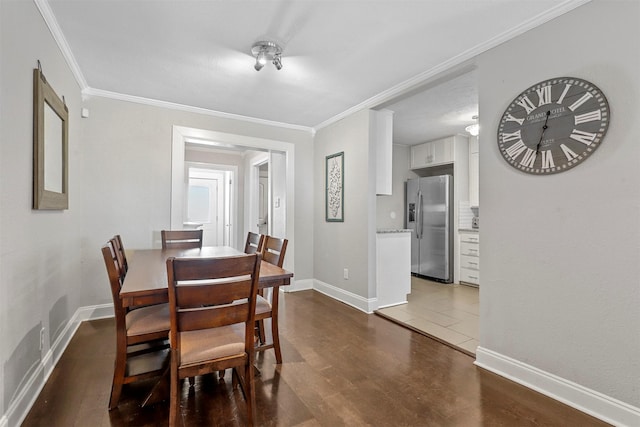 dining area with ornamental molding and dark hardwood / wood-style flooring