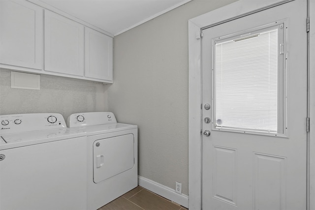 clothes washing area featuring cabinets and washer and clothes dryer