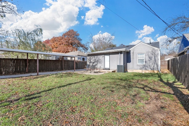 rear view of house featuring a patio area, central AC, and a lawn