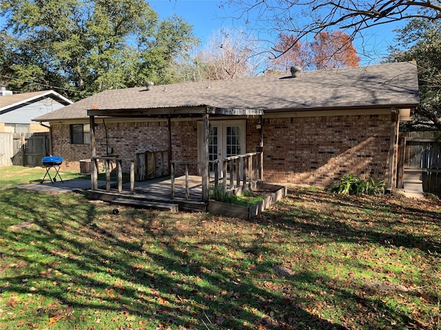 back of house with a lawn, a wooden deck, and french doors