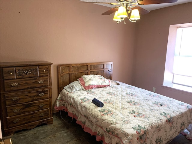 bedroom with ceiling fan and dark carpet