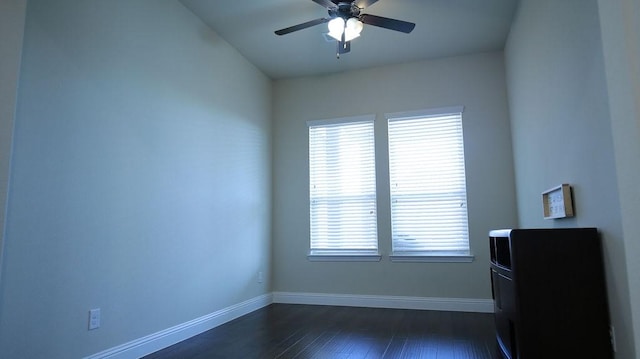 spare room with dark hardwood / wood-style flooring, ceiling fan, and a healthy amount of sunlight