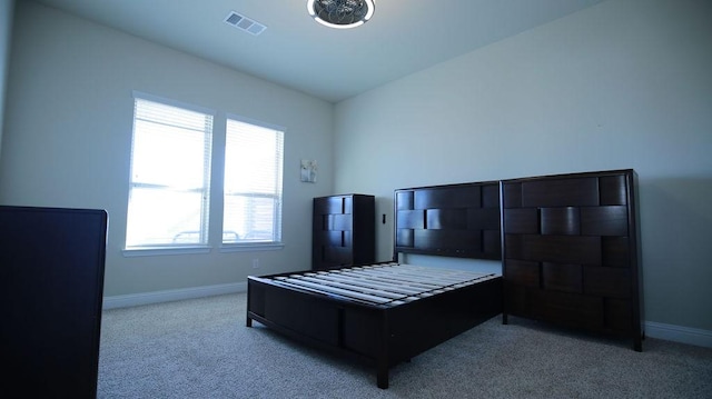 bedroom featuring multiple windows and light colored carpet